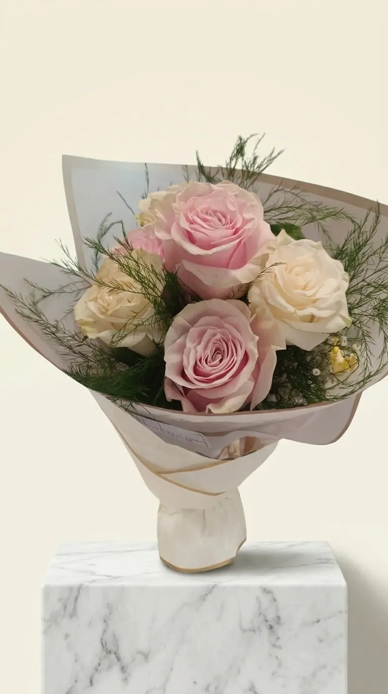 Ramo de rosas rosas y crema envuelto en papel